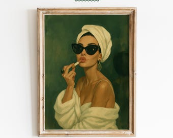 Pode incluir: Impressão artística emoldurada de uma mulher aplicando batom, usando uma toalha branca, óculos de sol e um roupão. A obra de arte tem uma estética vintage com um fundo verde. A impressão inclui o texto "FEMMAURA".