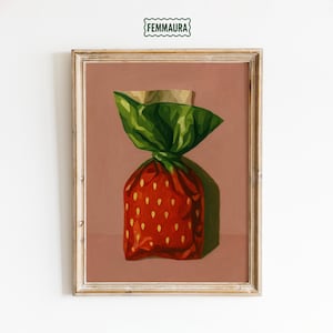 Może przedstawiać: Oprawione dzieło sztuki przedstawiające stylizowany cukierek truskawkowy. Cukierek jest owinięty w czerwoną papier z żółtymi kropkami i zielony papier. Grafika jest osadzona na stonowanym różowym tle, z tekstem "FEMMAURA" u góry.