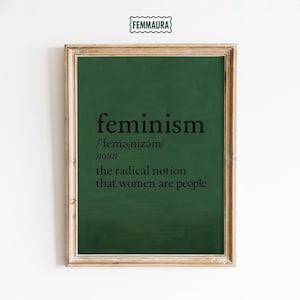 Può includere: Una stampa incorniciata con sfondo verde scuro e la parola "femminismo" in nero. La definizione include la pronuncia e la frase "la nozione radicale che le donne sono persone."