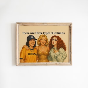 May include: Framed print featuring a vintage-style illustration of three women. The text "there are three types of lesbians" is at the top. The women are in various outfits, including a baseball cap and a gold dress.