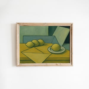 May include: A framed still life painting featuring lemons. The artwork depicts four yellow lemons, three on a table and one on a small plate. The background has geometric shapes in shades of green and blue.