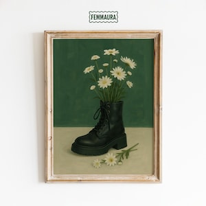 May include: Framed art print featuring a black combat boot filled with white daisies against a green background. The boot is the focal point, with a few loose flowers scattered below. The artwork has a vintage aesthetic.