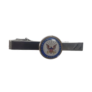 May include: Silver tie clip with a round, blue and white enamel emblem featuring the United States Navy seal.