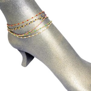 May include: Gold anklet with multiple strands of chain and colorful beads.