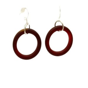 May include: A pair of dark red hoop earrings. Each earring features a circular, translucent design with a silver-colored hook. The earrings are displayed against a white background.