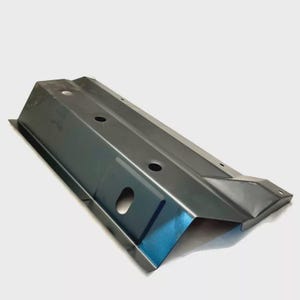 May include: A dark grey metal automotive component featuring several circular apertures and angled sides. The part is rectangular with a folded design, possibly for structural support or mounting.