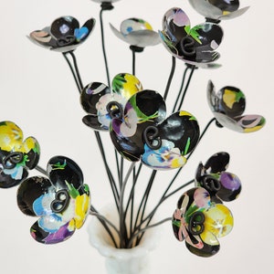 Può includere: Un bouquet di fiori di metallo con motivo floreale bianco e nero con steli di filo nero in un vaso bianco.