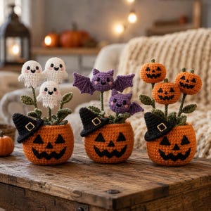 May include: Three crocheted Halloween decorations in orange pumpkin-shaped pots with black jack-o'-lantern faces and witch hats. One pot holds white ghosts, one holds purple bats, and one holds orange pumpkins, all with green stems and leaves.