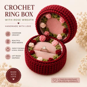 May include: A round, dark red crochet ring box featuring a rose wreath interior with pink, white, and red flowers. The box is open, revealing a soft pink velvet lining and a gold ring with a clear stone. Text reads CROCHET RING BOX WITH ROSE WREATH.