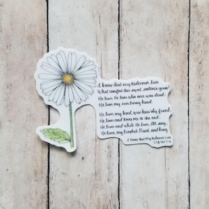 May include: A white daisy with a yellow center is drawn on a white sticker. The sticker also includes a handwritten quote about faith and redemption: "I know that my Redeemer lives What comfort this sweet sentence gives! He lives, He lives who once was dead. He lives, my ever living head. He lives, my kind, wise heavenly friend. He lives and loves me to the end. He lives and while He lives, I'll sing; He lives, my Prophet, Priest and King I Know that My Redeemer Lives LSB 461-1-6"