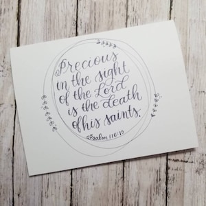 May include: A white card with a black circle and the text "Precious in the sight of the Lord is the death of his saints. Psalm 116:15" written in cursive.