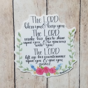 May include: A white sticker with a floral border and the text "The LORD bless you & keep you. The LORD make his face to shine upon you & be gracious unto you. The LORD lift up his countenance upon you & give you peace. Numbers 6:24-26"