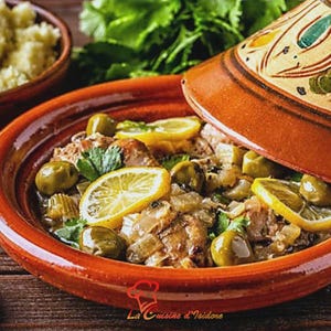 Puede incluir: Un plato de tagine marroqu&iacute; con aceitunas, rodajas de lim&oacute;n y hierbas, servido en una olla de terracota con tapa decorativa. El plato se presenta sobre una superficie de madera, con un cuenco de cusc&uacute;s al fondo. Incluye el texto "La Cuisine d'Isidore".
