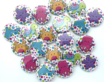 May include: A collection of 18 colorful, round buttons with various sea creatures on them. The buttons have a white background with colorful polka dots. The sea creatures include a crab, a starfish, a turtle, a dolphin, and an octopus.