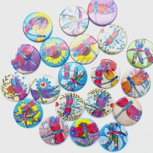 May include: Assortment of colorful round buttons with butterfly designs. Each button features a different butterfly pattern with vibrant colors and intricate details. The buttons are perfect for crafting, scrapbooking, and adding a touch of whimsy to any project.