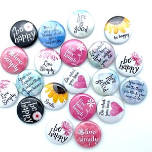 May include: Assortment of colorful round buttons with inspirational quotes and floral designs. The quotes include "be happy", "live simply", "life is good", "live love laugh", "you are capable of more than you know", "do what you love", "smile", "you must do the things you think you cannot do", and "let what you love be what you do".
