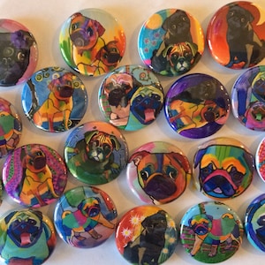 May include: A collection of 18 colorful round buttons featuring various images of pugs. The buttons are decorated with different patterns and colors, including black, white, brown, yellow, green, blue, and red.