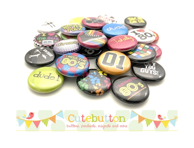 May include: A collection of 1.25 inch button pins with various 80s themed designs. The buttons feature phrases like "I Love the 80s", "Totally 80s", "I Miss the 80s", and "Break'n 80s".