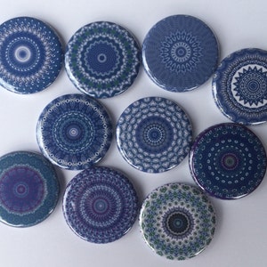 May include: Ten round blue and white mandala design buttons. The buttons have a variety of patterns and colors, including shades of blue, white, and green.