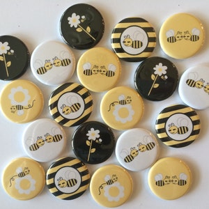 May include: A collection of 17 round, 1-inch diameter, button pins featuring various bee and flower designs. The designs include bees with black and yellow stripes, flowers with white petals and yellow centers, and a combination of both. The buttons are perfect for adding a touch of whimsy to bags, jackets, or other accessories.