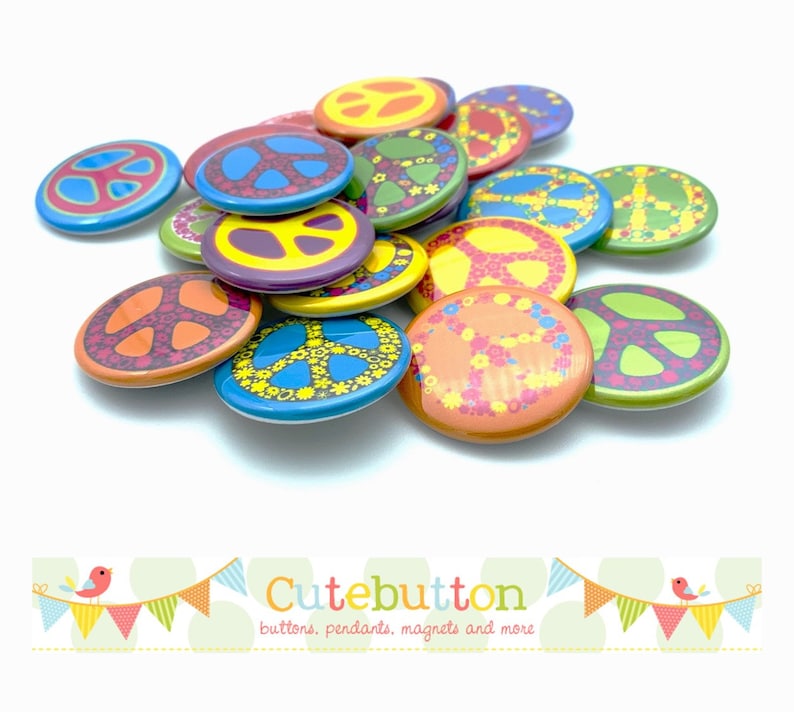 May include: A pile of colorful peace sign buttons with various floral and geometric designs. The buttons are all round and about 1 inch in diameter. The text "Cutebutton" is visible at the bottom of the image.