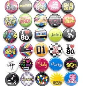 May include: A collection of 20 colorful 1-inch button pins with various 1980s themed designs. The pins feature text, images, and graphics related to the 1980s, including the words "I love the 80s", "Totally Rad", "Save Ferris", "Gnarly", "Dude", "Break'n", "Stay Gold Ponyboy", "Take a Chill Pill", and "80's Baby".