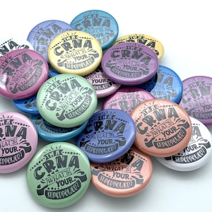 May include: A collection of colorful round buttons with the text "I'm a CRNA, What's Your Superpower?" printed on them.