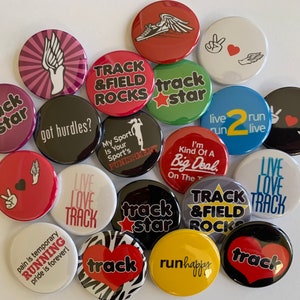 May include: A collection of 16 colorful round buttons with various track and field themed designs. The buttons feature phrases like "track star", "live run live", "track & field rocks", and "got hurdles?"