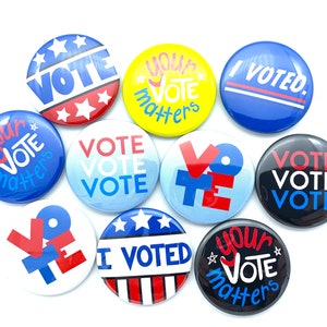 May include: A collection of round buttons with political slogans. The buttons feature the words "VOTE", "I VOTED", and "Your Vote Matters" in various colors, including red, white, blue, and yellow. Some buttons have star and stripe designs.