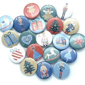 May include: A collection of 16 round Christmas-themed buttons featuring various designs, including a nutcracker, a Christmas tree, a rocking horse, a ballerina, and a gift box. The buttons are colorful and have a variety of patterns.