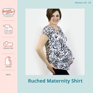 Puede incluir: Una camiseta de maternidad de rayas de cebra en blanco y negro con un diseño fruncido. La camiseta se muestra en una modelo con un fondo claro.