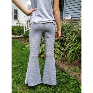 May include: Gray striped flared pants with a wide leg. The pants are made of a soft, comfortable fabric and have a relaxed fit.
