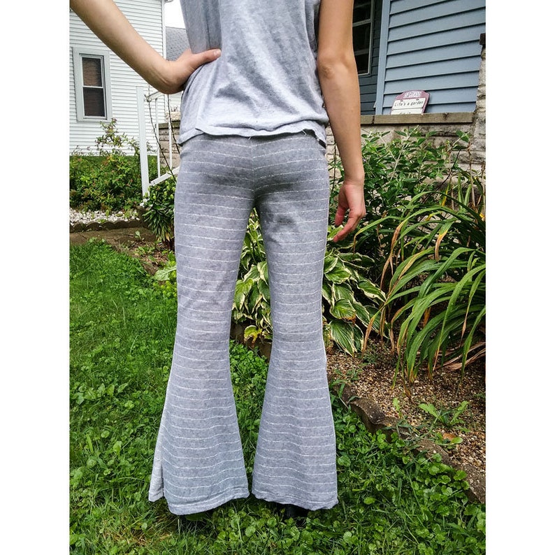 May include: Gray striped flared pants with a wide leg. The pants are made of a soft, comfortable fabric and have a relaxed fit.