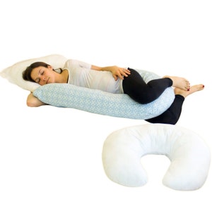 May include: A white and blue patterned pregnancy pillow with a woman sleeping on it. A white U-shaped pillow is also shown in the image.