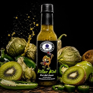 Op de afbeelding: Een fles Killer Kiwi hete saus van Danger Berry Spice Co. met een zwarte dop en etiket. Het etiket toont een kiwi-cartoonfiguur, de tekst Killer Kiwi en de vermelding 5 FL OZ (148 ml). Omringd door verse kiwi's en groene pepers.