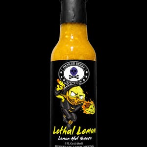 Op de afbeelding: Een fles van 148 ml gele hete saus met een zwarte dop. Het etiket bevat een paars schedel- en kruisbotlogo, de tekst Danger Berry Spice Co en een gele citroenfiguur. De tekst luidt Lethal Lemon, Lemon Hot Sauce, 5 fl oz (148ml) en REFRIGERATE AFTER OPENING.