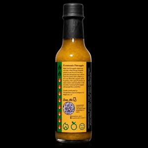 K&ouml;nnte beinhalten: Eine Glasflasche mit Pyromania Pineapple scharfer So&szlig;e und schwarzem Verschluss. Das gelbe Etikett enth&auml;lt eine Produktbeschreibung, einen QR-Code und eine Zutatenliste mit Ananas, Zucker, Jalapeno, Apfelessig, Ghost Pepper und Salz.