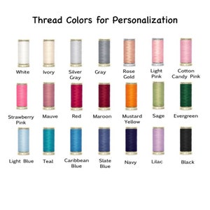 May include: A chart of thread colors for personalization. The colors are arranged in three rows of eight colors each. The colors include white, ivory, silver gray, gray, rose gold, light pink, cotton candy pink, strawberry pink, mauve, red, maroon, mustard yellow, sage, evergreen, light blue, teal, Caribbean blue, slate blue, navy, lilac, and black.