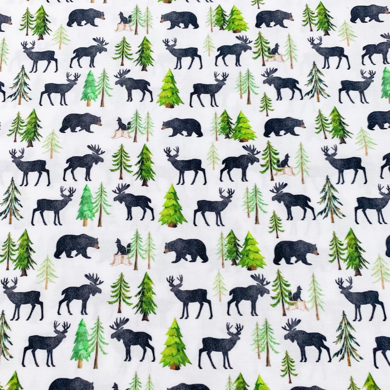 May include: A white fabric with a repeating pattern of black moose, deer, bears, and pine trees. The pattern is a woodland theme.