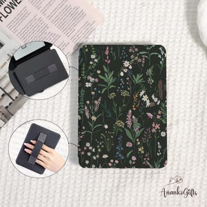 May include: Black tablet case with a floral pattern featuring various wildflowers in shades of pink, white, yellow, and blue. The case has a built-in hand strap and a stand. The brand name "AnankoGifts" is visible.