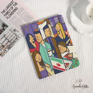 May include: A colorful notebook featuring a cartoon illustration of a group of people in a room. The notebook has a purple background with various characters and objects. A magazine with the text "THE LARGEST FAMILY OF THE FLOWERING" is also visible.