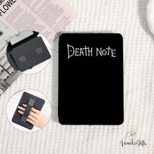 May include: Black tablet case with the text "Death Note" in white script. The case has a hand strap for easy holding. The image also shows a close-up of the case with a stand and a newspaper in the background.