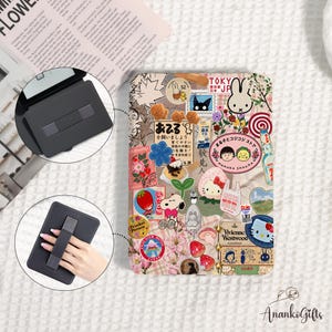 May include: A rectangular e-reader case featuring a collage of colorful stickers including cartoon characters, Japanese text, floral patterns, and food illustrations. The case includes a black back panel with an integrated elastic hand strap.