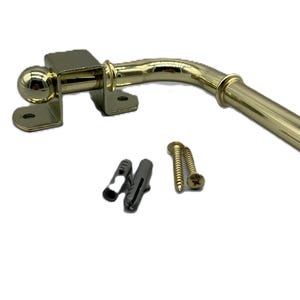 May include: A gold-coloured curtain rod with mounting hardware, including screws and wall anchors. The rod has a curved design and a decorative ball at the end. The hardware is gold-toned and ready for installation.