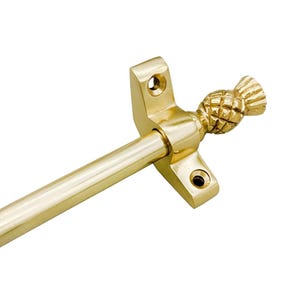May include: A gold-colored curtain rod with a pineapple finial. The rod has a smooth, cylindrical design, and the pineapple is intricately detailed. The mounting brackets are square with rounded edges and screw holes.