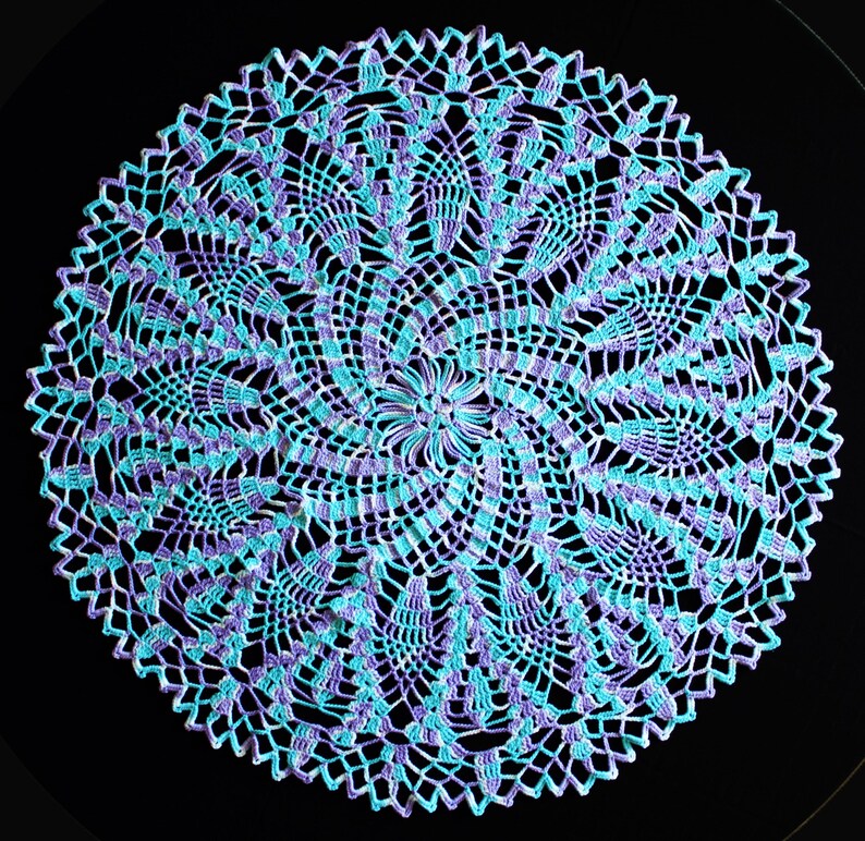 Pu&ograve; includere: Un centrino rotondo fatto a mano con un motivo a spirale. Il centrino &egrave; lavorato all'uncinetto con filato blu chiaro e viola. L'intricato motivo traforato crea un pezzo delicato e decorativo, perfetto per aggiungere un tocco di fascino fatto a mano.