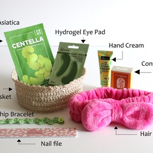 May include: A collection of self-care items including a Centella Asiatica mask, hydrogel eye pads, hand cream, and a pink hair band. A handmade crochet basket holds the skincare products. Also included are a friendship bracelet and a nail file.
