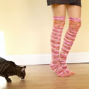 May include: A pair of pink and orange striped thigh-high socks with a subtle shimmer.
