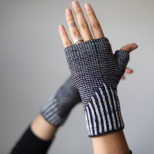 May include: A pair of black and white fingerless gloves with a striped pattern on the cuff.
