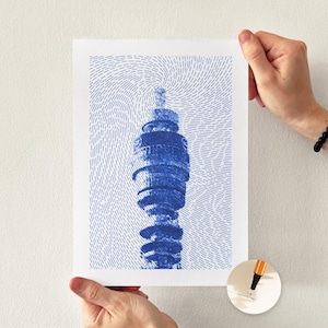 May include: A white rectangular art print featuring a blue ink illustration of the BT Tower in London. The image is composed of dense, swirling blue dashed lines that form the structure of the tower against a white background.